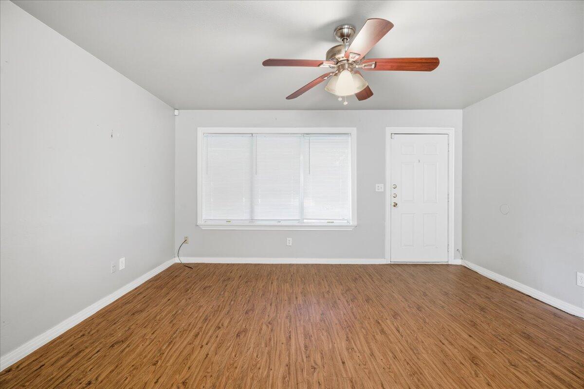 4115 31st Street Lubbock, TX 79410 - Photo 3 of 16 a view of room with window ceiling fan and wooden floor