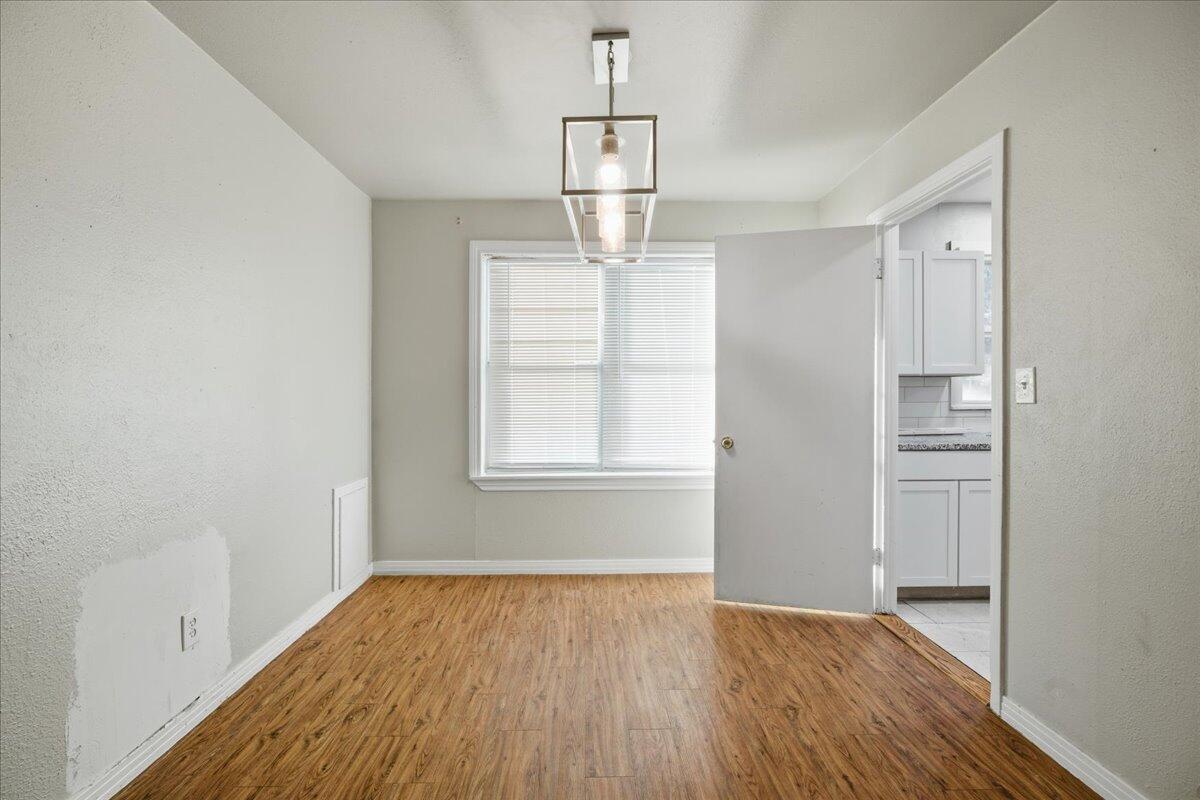 4115 31st Street Lubbock, TX 79410 - Photo 4 of 16 an empty room with wooden floor cabinet and windows