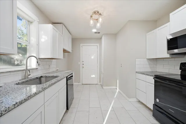 a kitchen that has a sink and a stove in it