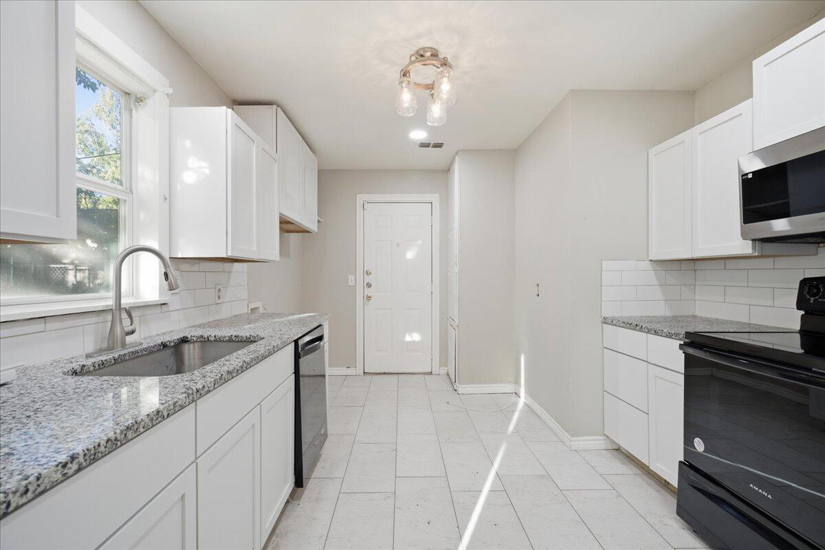 4115 31st Street Lubbock, TX 79410 - Photo 6 of 16 a kitchen that has a sink and a stove in it