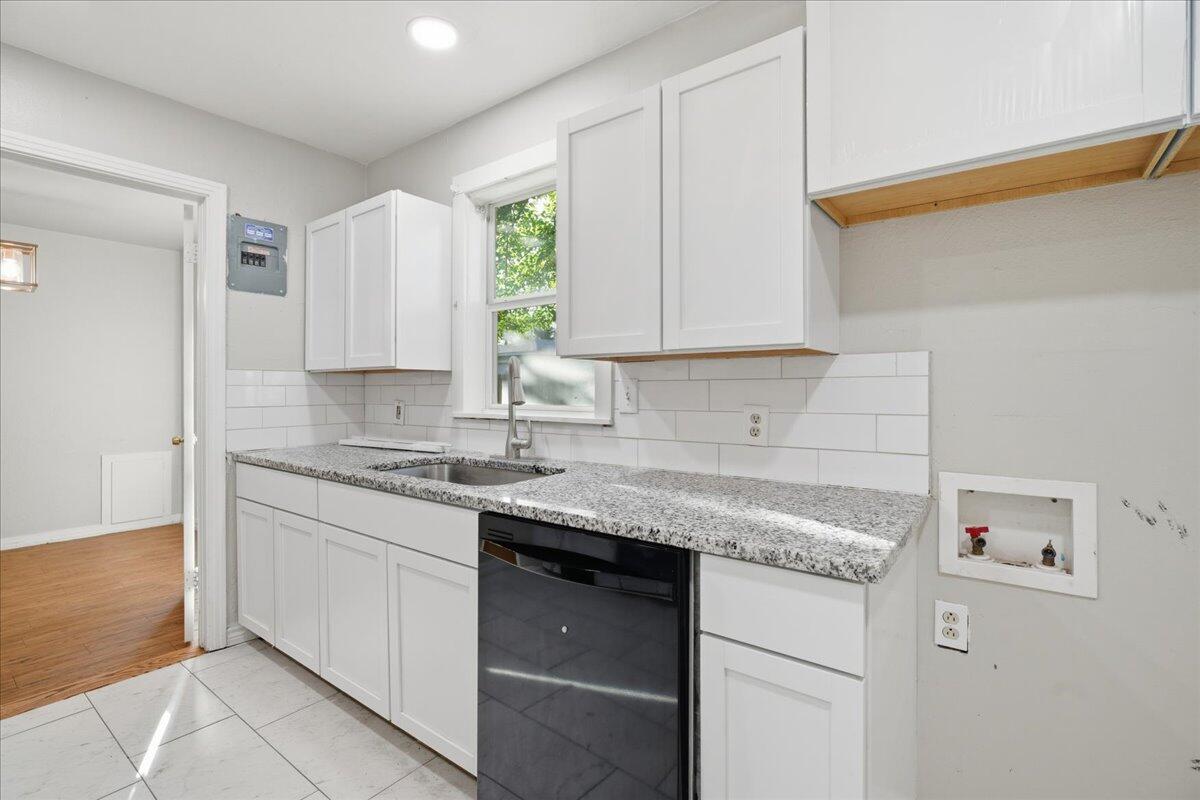 4115 31st Street Lubbock, TX 79410 - Photo 8 of 16 a kitchen with stainless steel appliances granite countertop a sink stove and cabinets