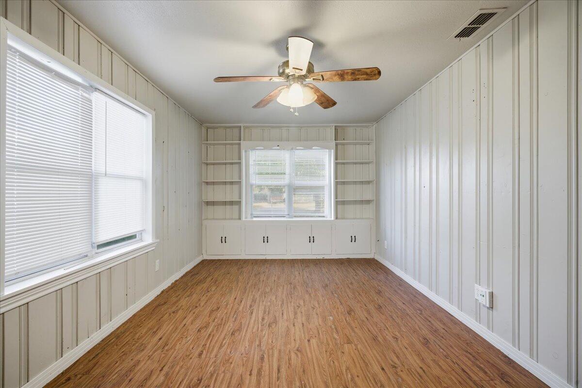 4115 31st Street Lubbock, TX 79410 - Photo 9 of 16 an empty room with wooden floor chandelier fan and windows