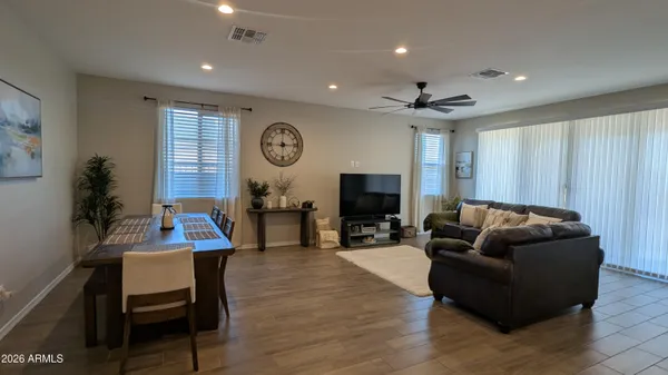 a living room with furniture a clock on wall and a window