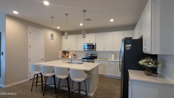 a kitchen with a dining table cabinets and refrigerator