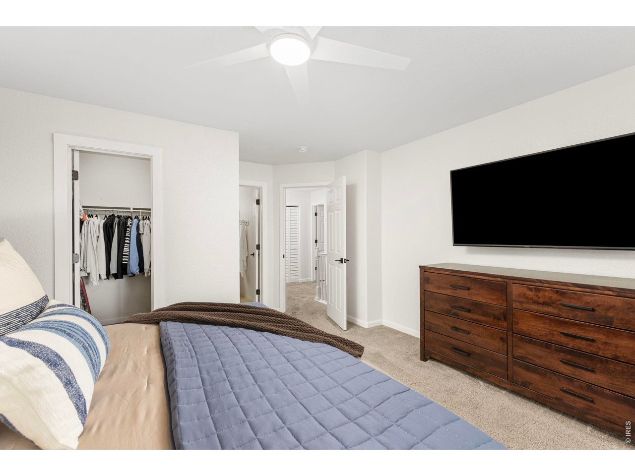 6531 St Vrain Ranch Boulevard Firestone, CO 80504 - Photo 17 of 30 a bedroom with a bed and a flat screen tv