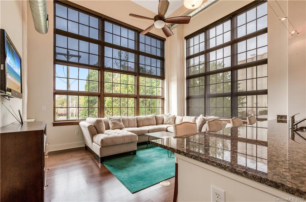 715 North Graham Street, Unit 210 Charlotte, NC 28202 - Photo 1 of 17 a living room with furniture and a floor to ceiling window