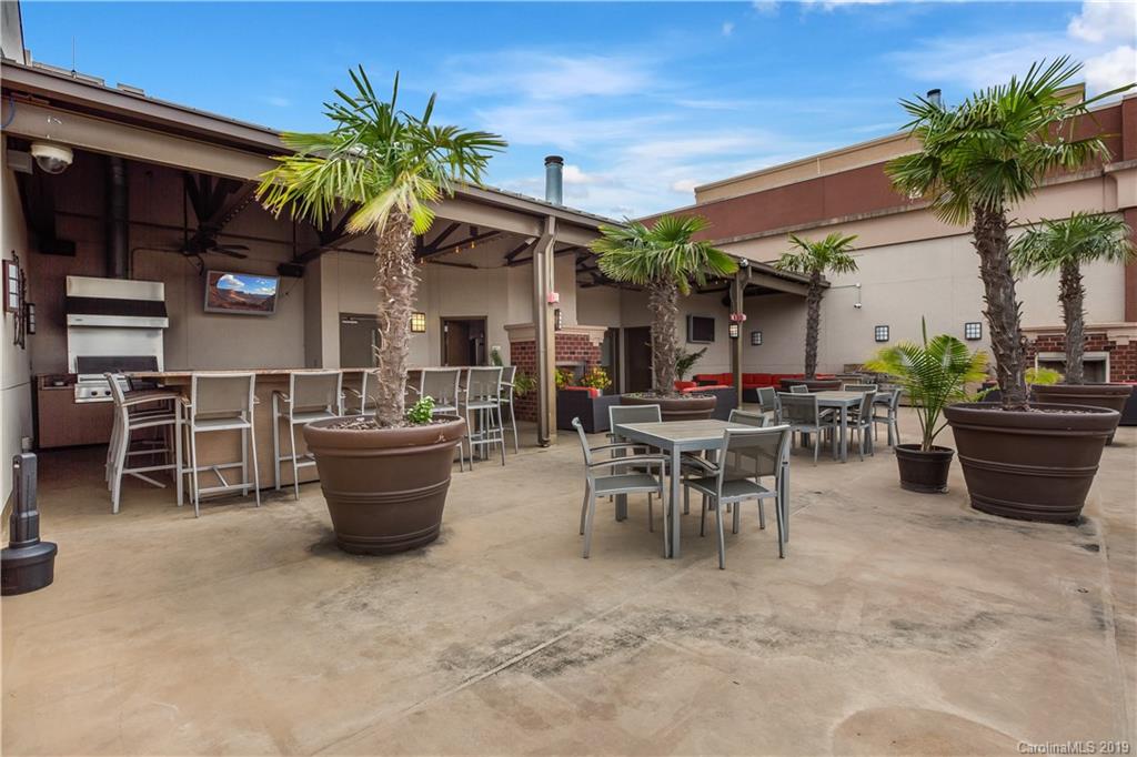 715 North Graham Street, Unit 210 Charlotte, NC 28202 - Photo 14 of 17 a view of a patio with table and chairs potted plants and palm tree