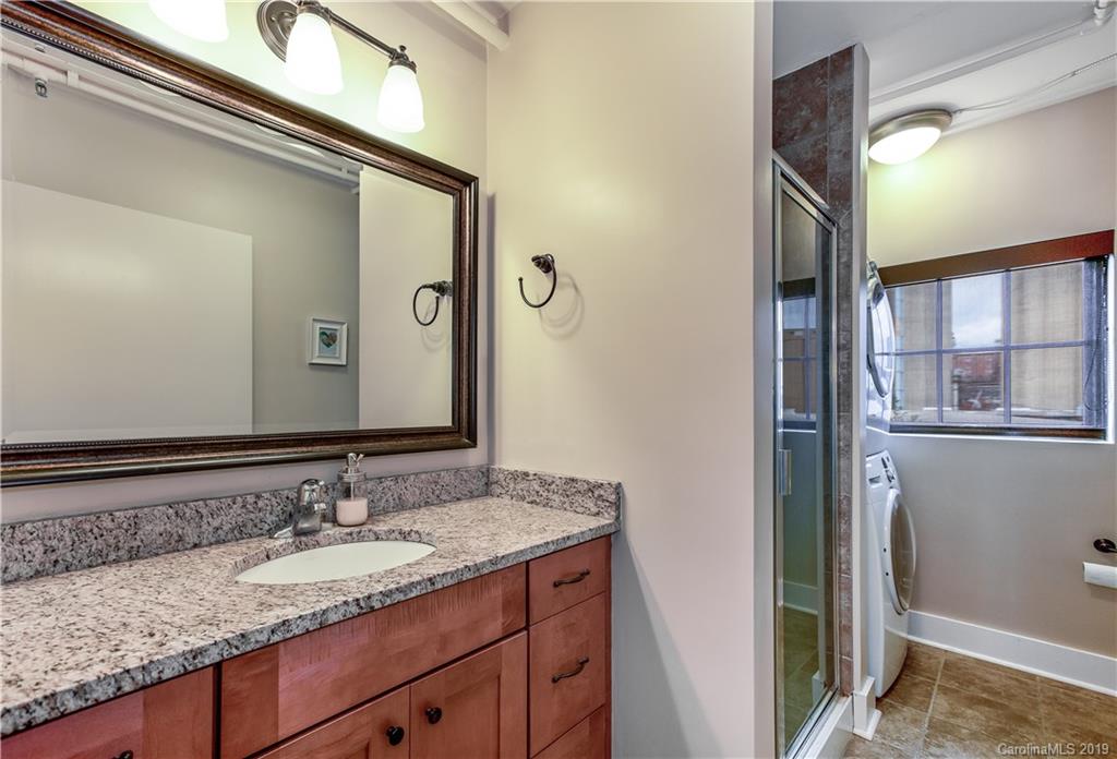 715 North Graham Street, Unit 210 Charlotte, NC 28202 - Photo 3 of 17 a bathroom with a granite countertop sink and a mirror