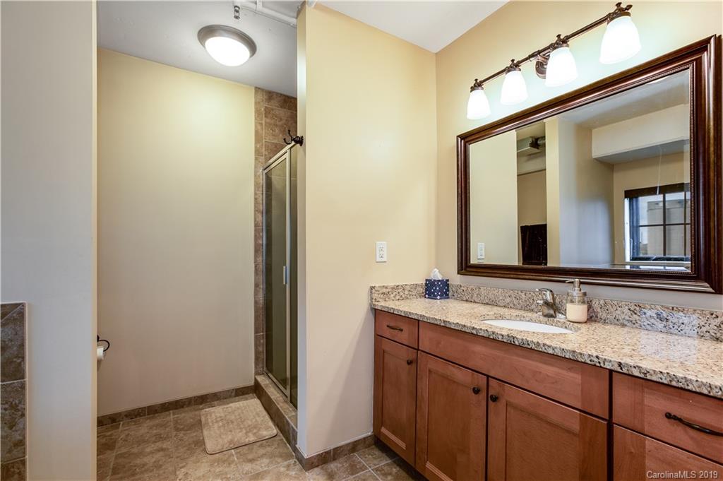 715 North Graham Street, Unit 210 Charlotte, NC 28202 - Photo 9 of 17 a bathroom with a granite countertop sink and a mirror
