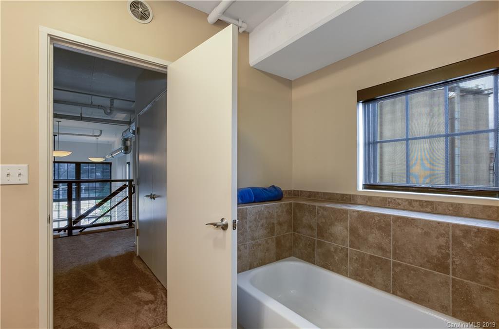 715 North Graham Street, Unit 210 Charlotte, NC 28202 - Photo 10 of 17 a bathroom with a tub and a window