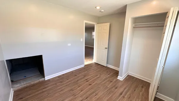 an empty room with wooden floor and cabinet