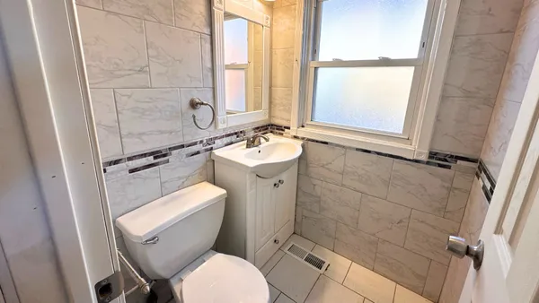 a bathroom with a toilet sink and mirror