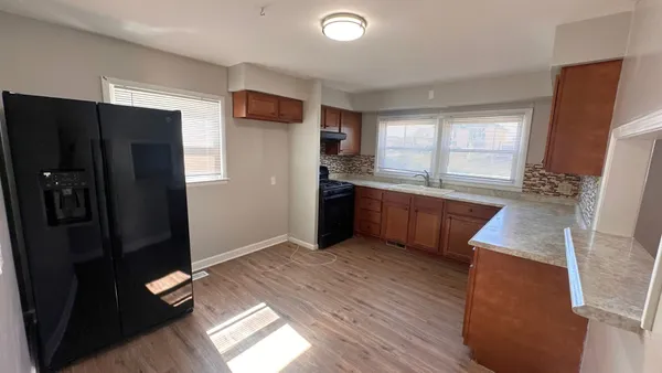 a kitchen with stainless steel appliances granite countertop a refrigerator and a sink