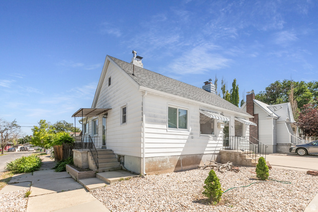 59 East Pinehurst Street Tooele, UT 84074 - Photo 3 of 22 White siding exterior with a pitched roof and a chimney
