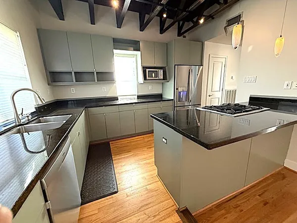 a kitchen with granite countertop a sink stove and cabinets