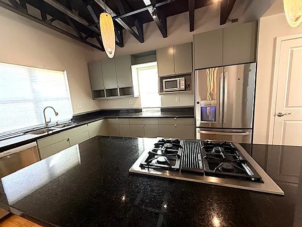 a kitchen with kitchen island a stove and a sink