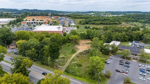 an aerial view of residential houses with outdoor space and trees