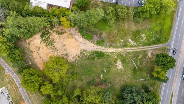 a view of a lush green forest with trees and some houses