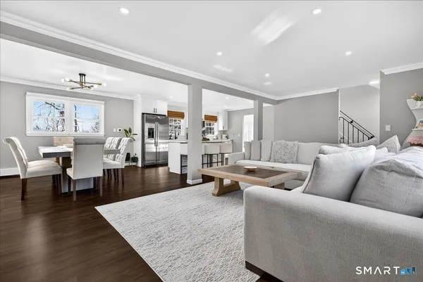 a living room with furniture wooden floor and a large window
