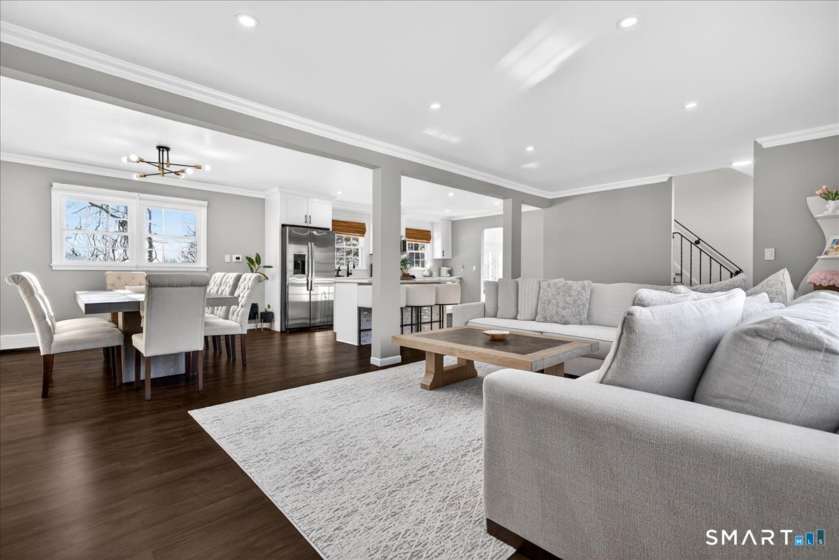 a living room with furniture wooden floor and a large window