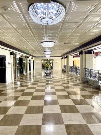 a view of a lobby with a chandelier and rug