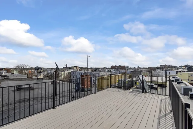 a view of a roof deck with table and chairs a barbeque with wooden floor
