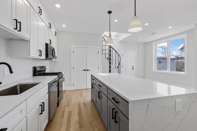 a kitchen with kitchen island a sink stove and wooden floor