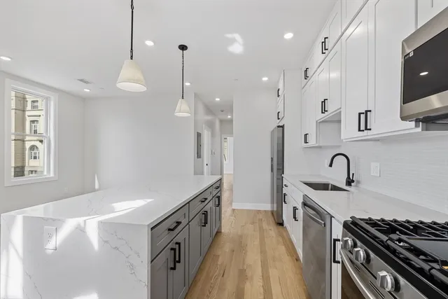 a kitchen with stainless steel appliances granite countertop a sink stove and refrigerator