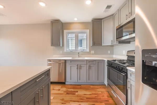 a kitchen with stainless steel appliances granite countertop a stove a sink and a microwave