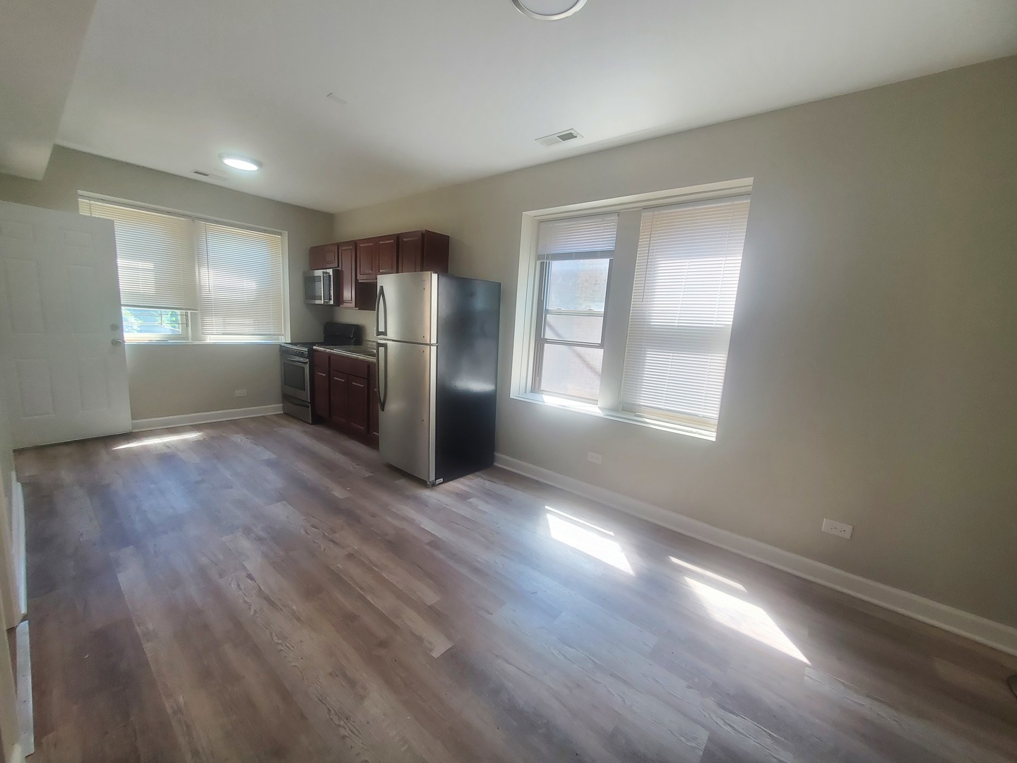 711 West 74th Street, Unit 1 Chicago, IL 60621 - Photo 5 of 9 a view of an empty room with window and wooden floor