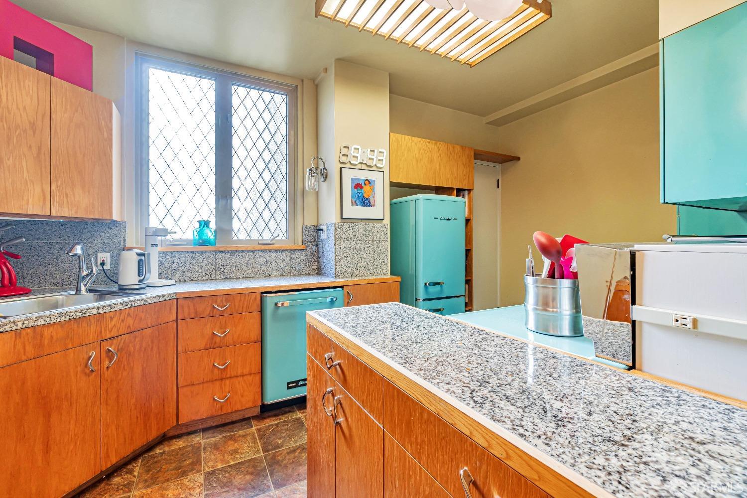 850 Powell Street, Unit 603 San Francisco, CA 94108 - Photo 16 of 47 a kitchen with stainless steel appliances granite countertop a sink dishwasher and a refrigerator with wooden cabinets