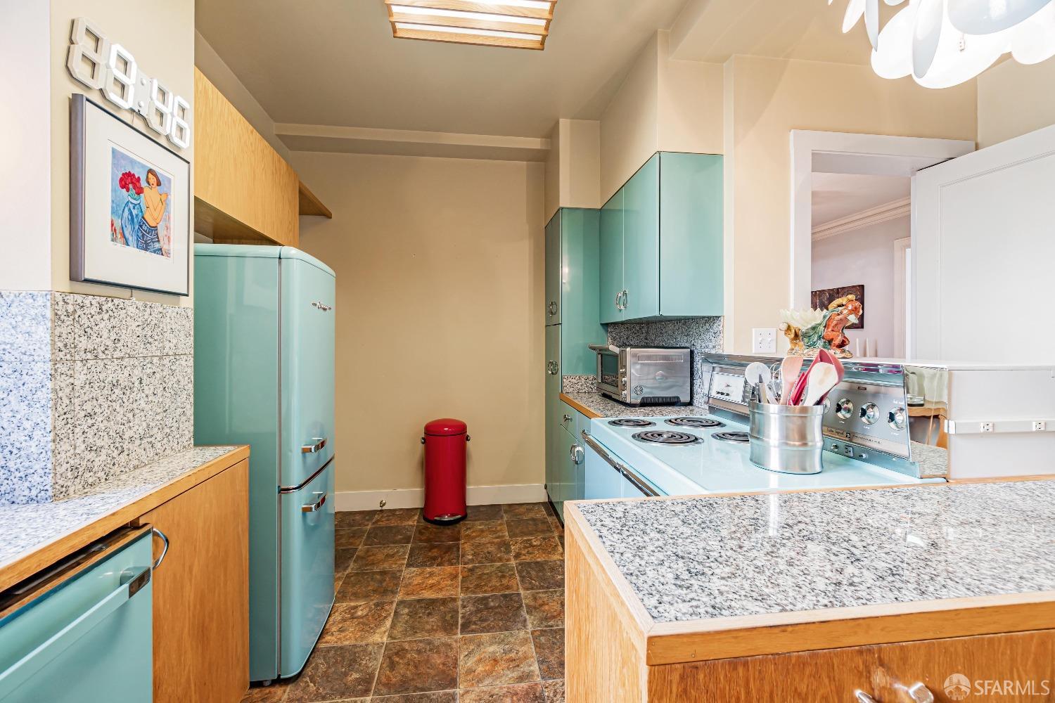 850 Powell Street, Unit 603 San Francisco, CA 94108 - Photo 20 of 47 a kitchen with granite countertop a sink a stove and wooden cabinets