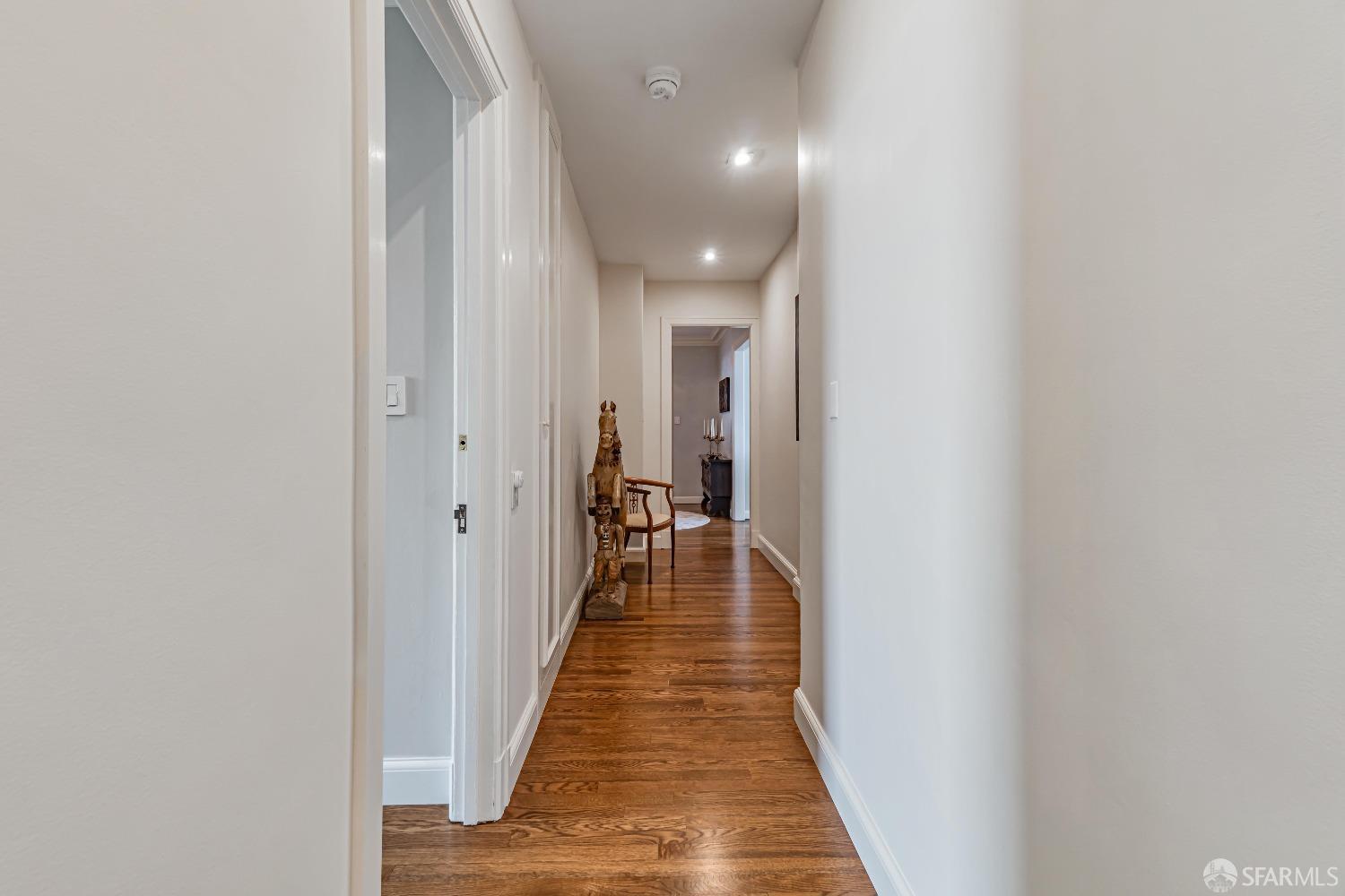 850 Powell Street, Unit 603 San Francisco, CA 94108 - Photo 24 of 47 a view of a hallway with wooden floor and a bathroom