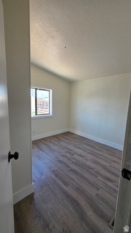 1450 North Dixie Downs Road, Unit 51 St. George, UT 84770 - Photo 23 of 25 Spacious room featuring vaulted ceilings, wood-finish flooring, white baseboards, and a window with a white frame