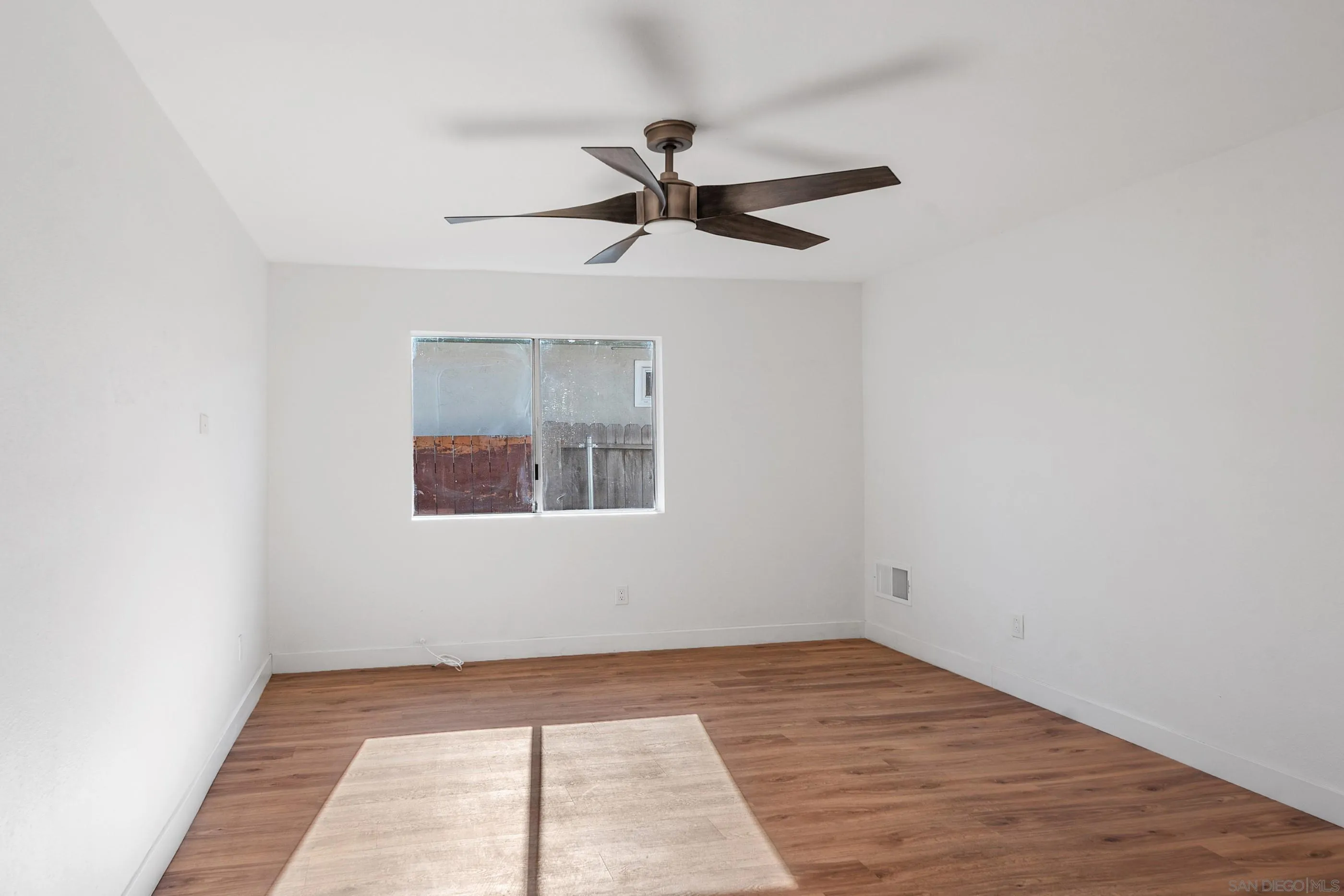 628 Paraiso Avenue Spring Valley, CA 91977 - Photo 11 of 38 an empty room with a chandelier fan and windows