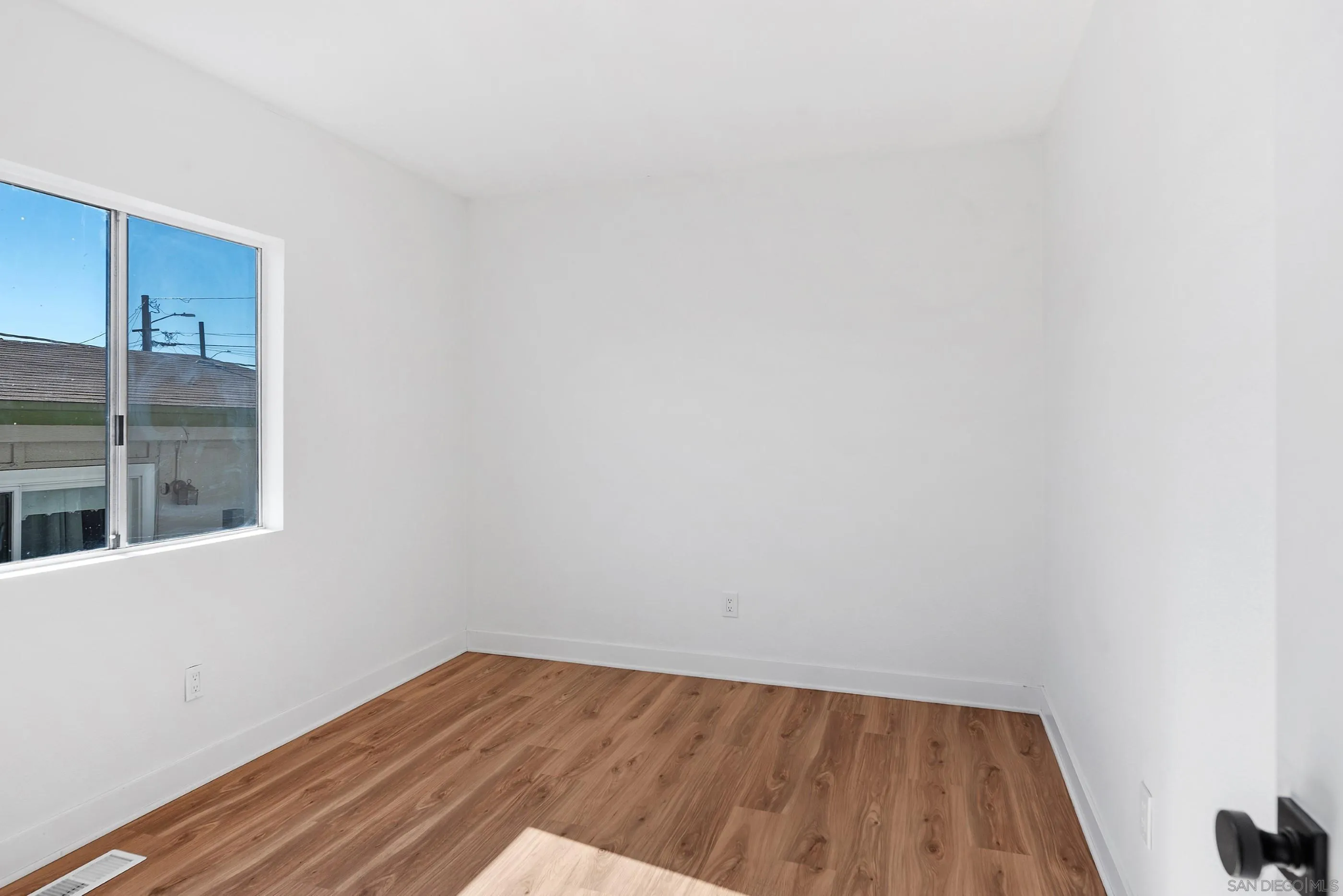 628 Paraiso Avenue Spring Valley, CA 91977 - Photo 13 of 38 a view of an empty room with wooden floor and a window