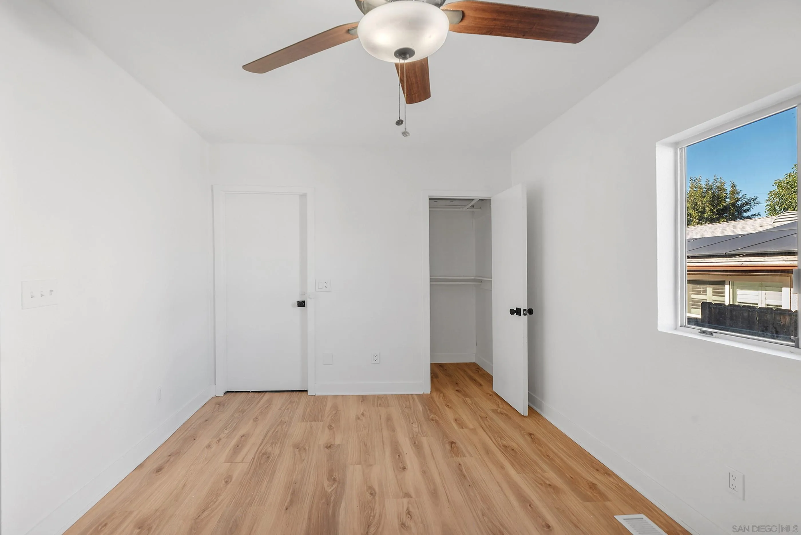 628 Paraiso Avenue Spring Valley, CA 91977 - Photo 17 of 38 a view of a room with wooden floor ceiling fan and window