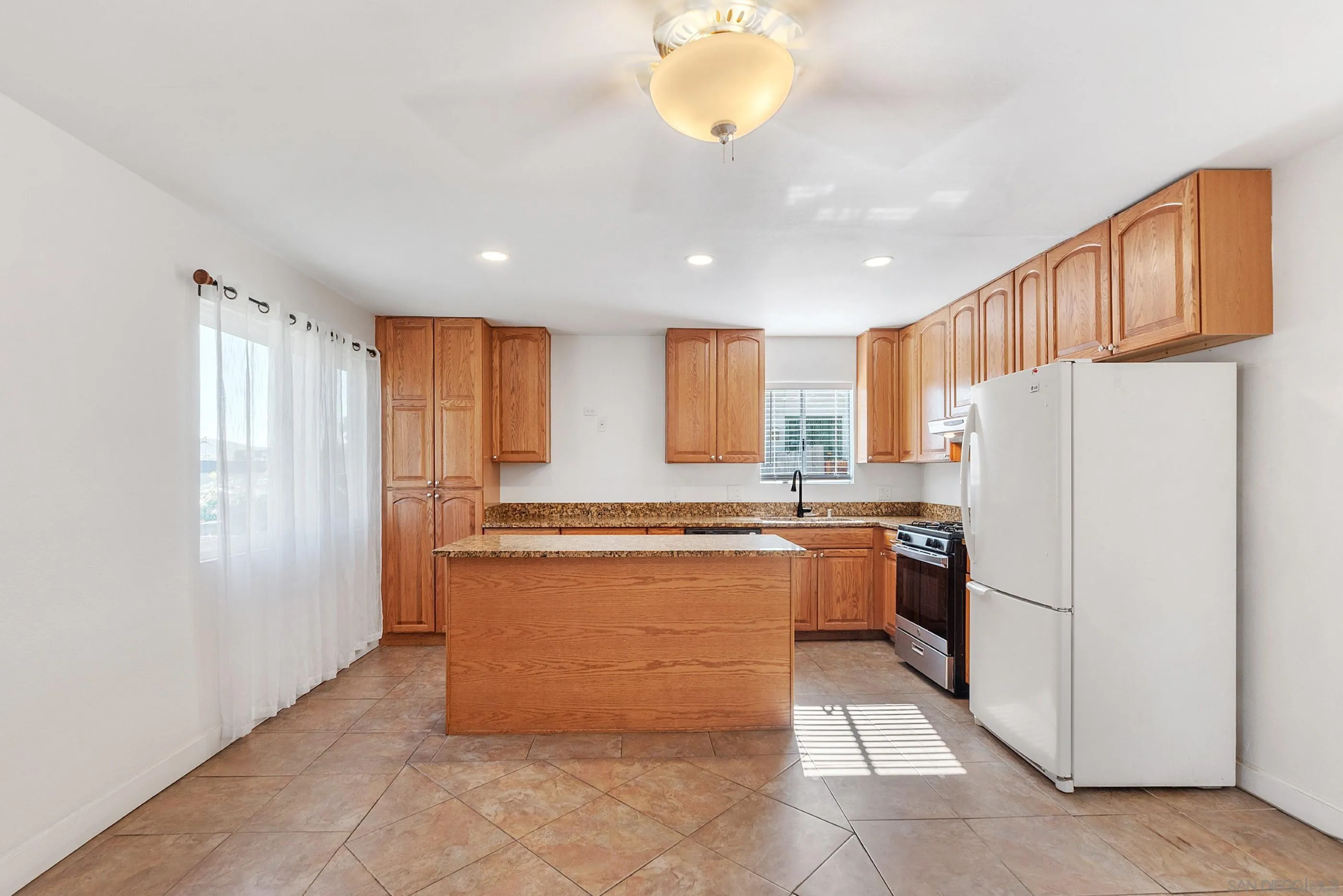 628 Paraiso Avenue Spring Valley, CA 91977 - Photo 7 of 38 a kitchen with refrigerator and cabinets