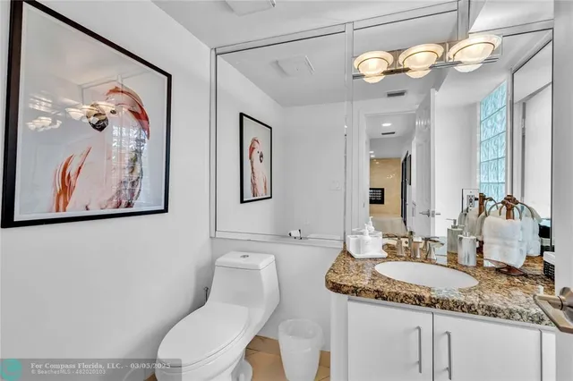 a bathroom with a granite countertop sink a toilet and a mirror