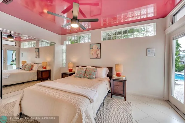 a bedroom with a bed a chandelier and large window