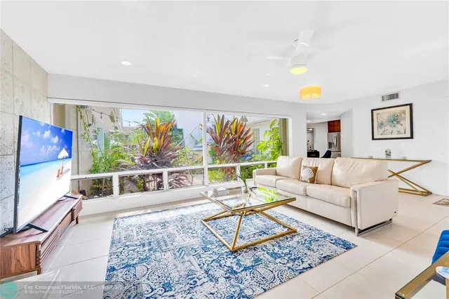 a living room with furniture a rug and a large window