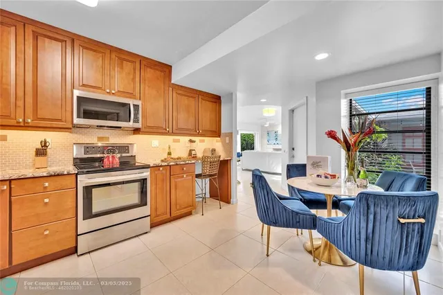 a kitchen with stainless steel appliances kitchen island granite countertop a kitchen island hardwood floor and a sink