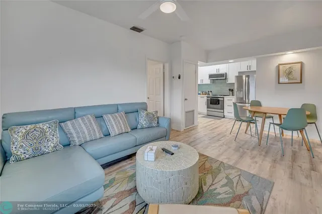 a living room with furniture and a dining table with wooden floor