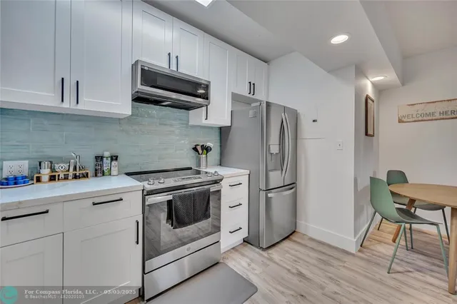 a kitchen with stainless steel appliances a stove a refrigerator and a microwave