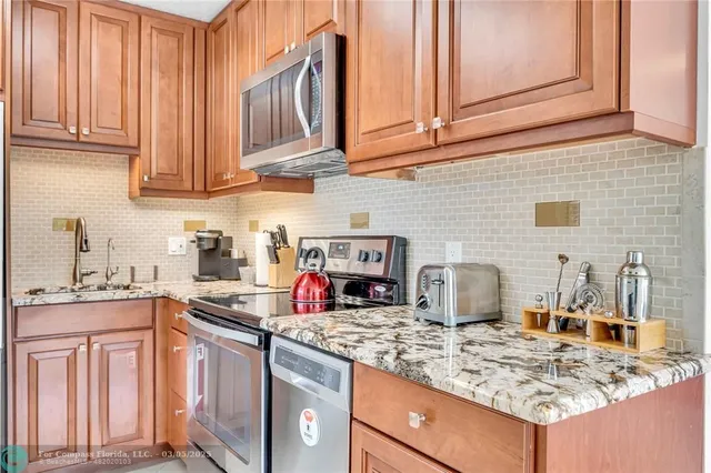 a kitchen with stainless steel appliances granite countertop a sink stove and cabinets