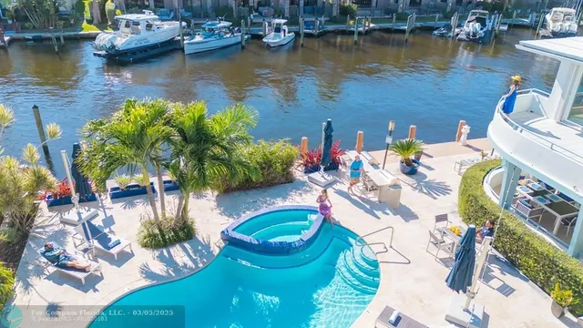 a view of a swimming pool with a patio and garden