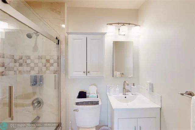 a bathroom with a toilet sink shower and mirror