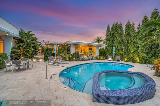 a view of swimming pool with outdoor seating and plants in the background
