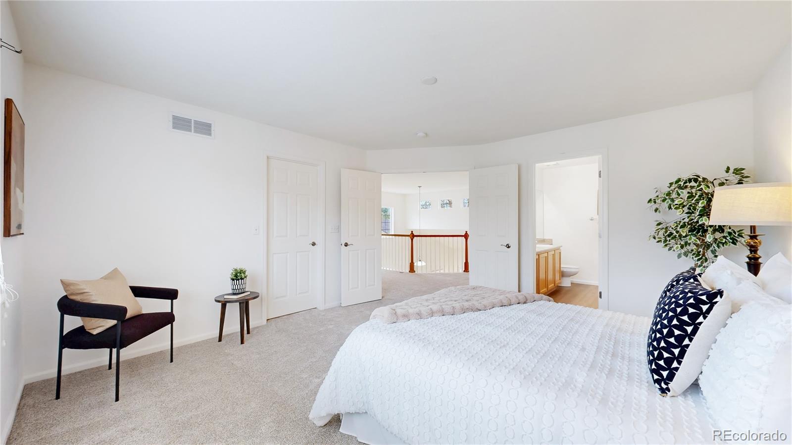 11738 Zenobia Loop Westminster, CO 80031 - Photo 21 of 34 a spacious bedroom with a bed table and a chair