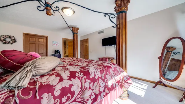 a bedroom with bed and a mirror